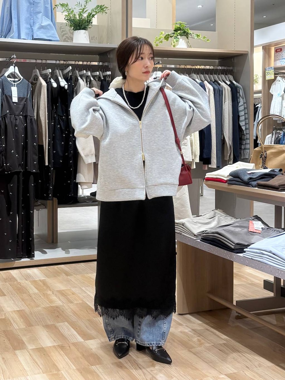 レッド系のショルダーバッグ、ブラック系のTシャツ/カットソー、ブルー系のデニムパンツを着用したレディースの春コーディネートの5枚目の写真