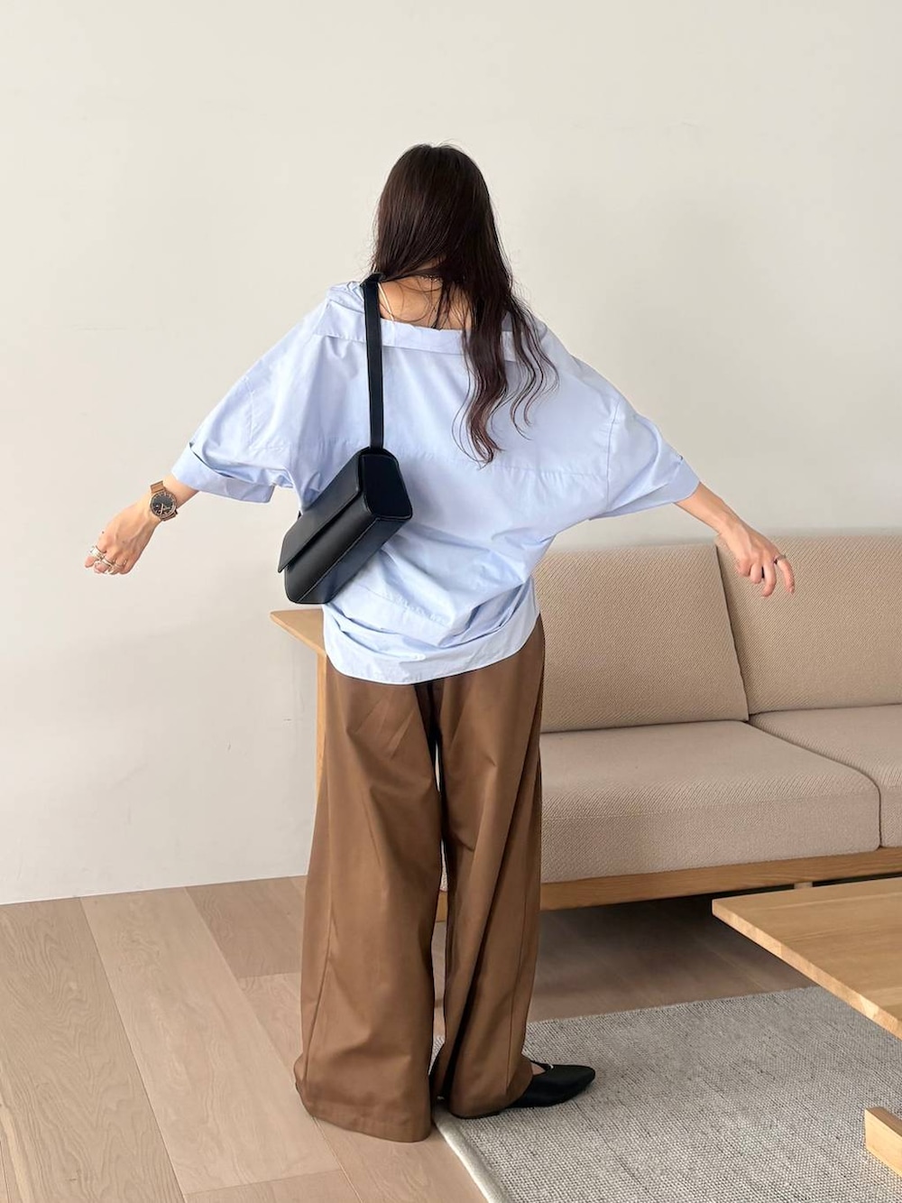 ブラック系のパンプス、ブルー系のシャツ/ブラウスを着用したレディースの夏コーディネートの3枚目の写真