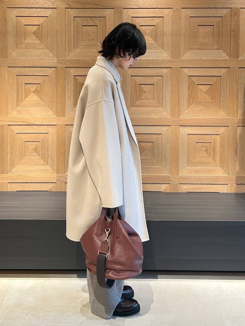 ブラウン系のショルダーバッグ、ベージュ系のその他パンツ、ホワイト系のシャツ/ブラウスを着用したレディースの秋コーディネートの2枚目の写真