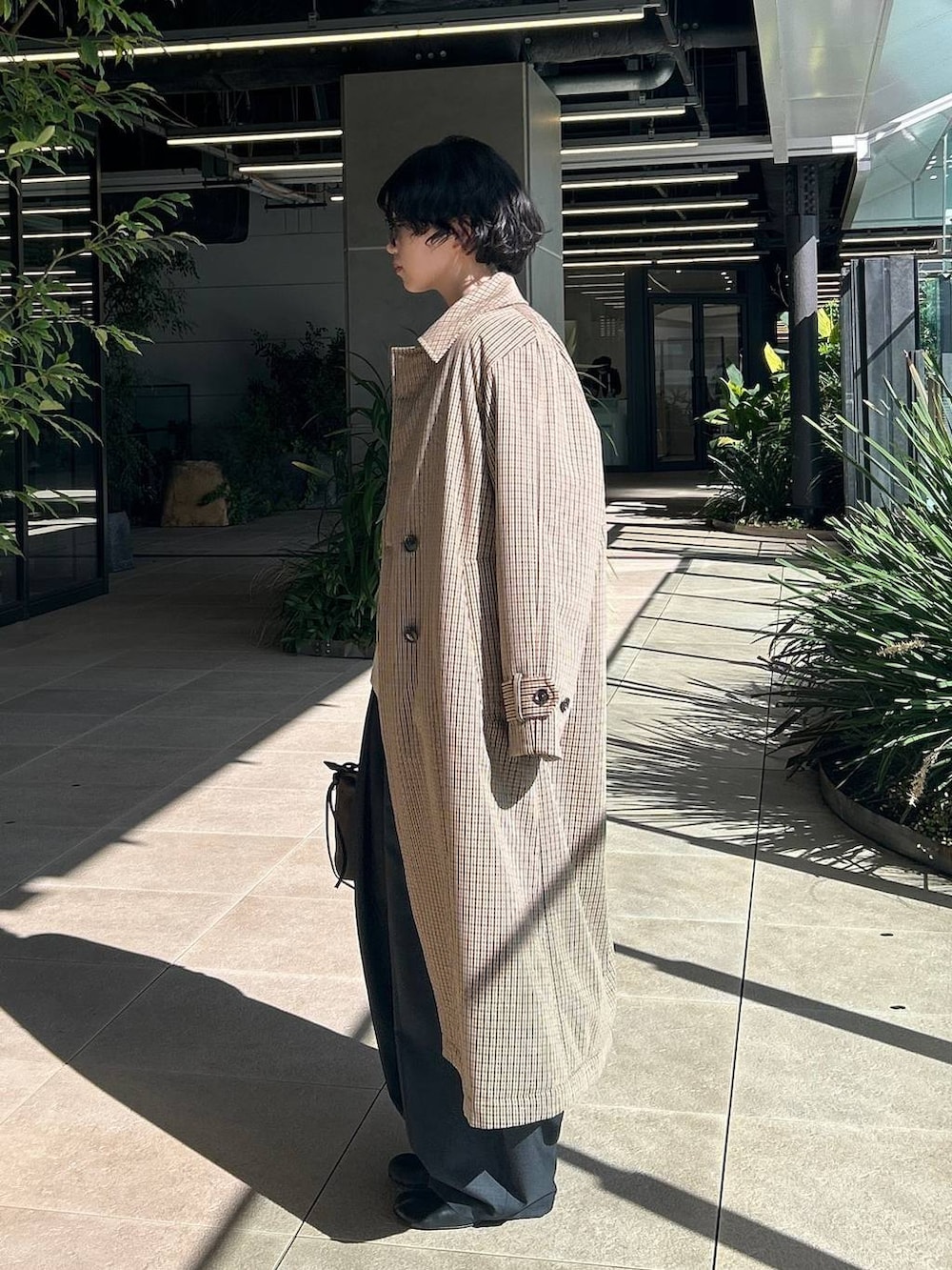 ベージュ系のチェスターコート、ホワイト系のニット/セーター、グレー系のその他パンツを着用したレディースの秋コーディネートの4枚目の写真