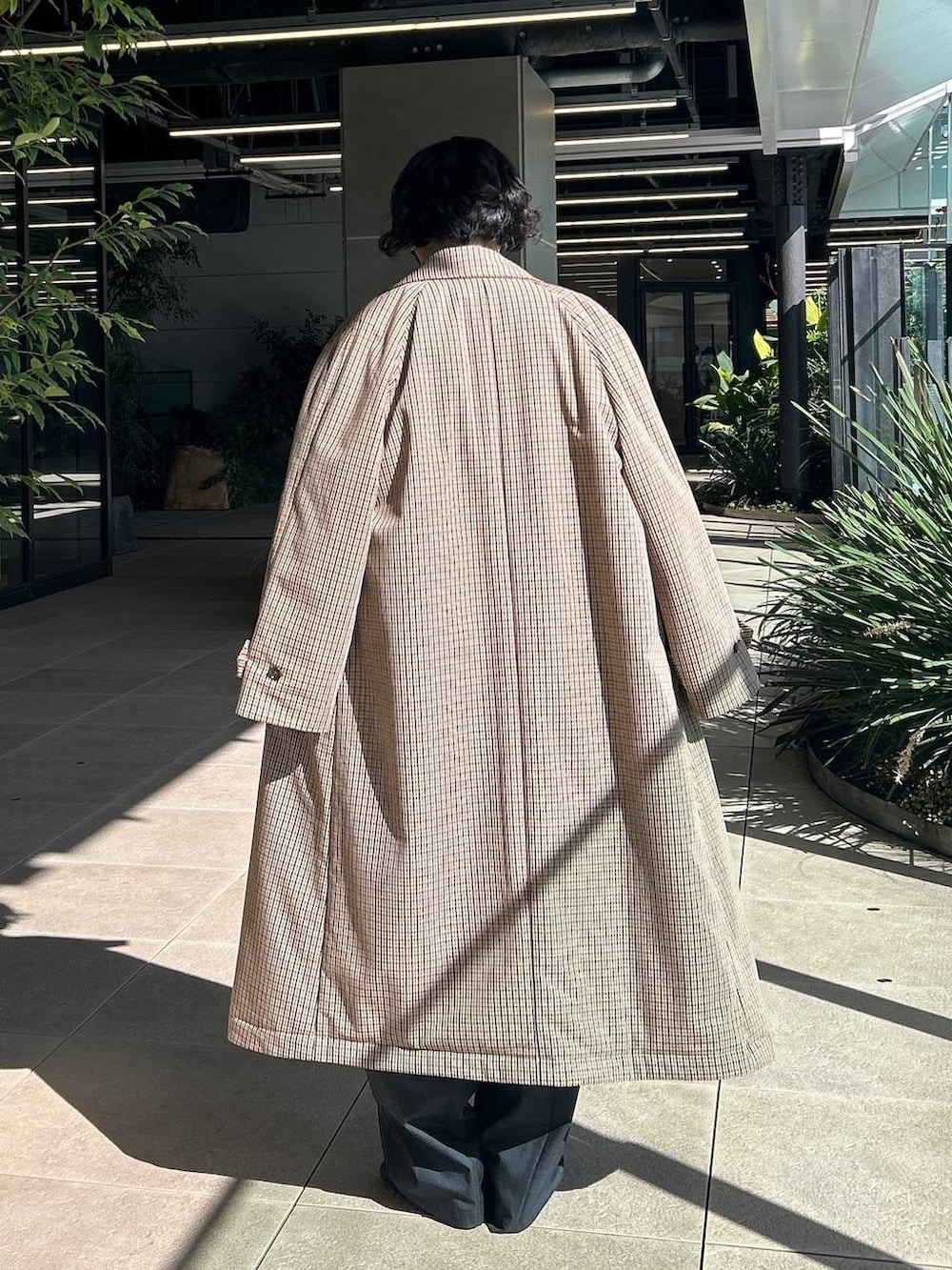 ベージュ系のチェスターコート、ホワイト系のニット/セーター、グレー系のその他パンツを着用したレディースの秋コーディネートの3枚目の写真