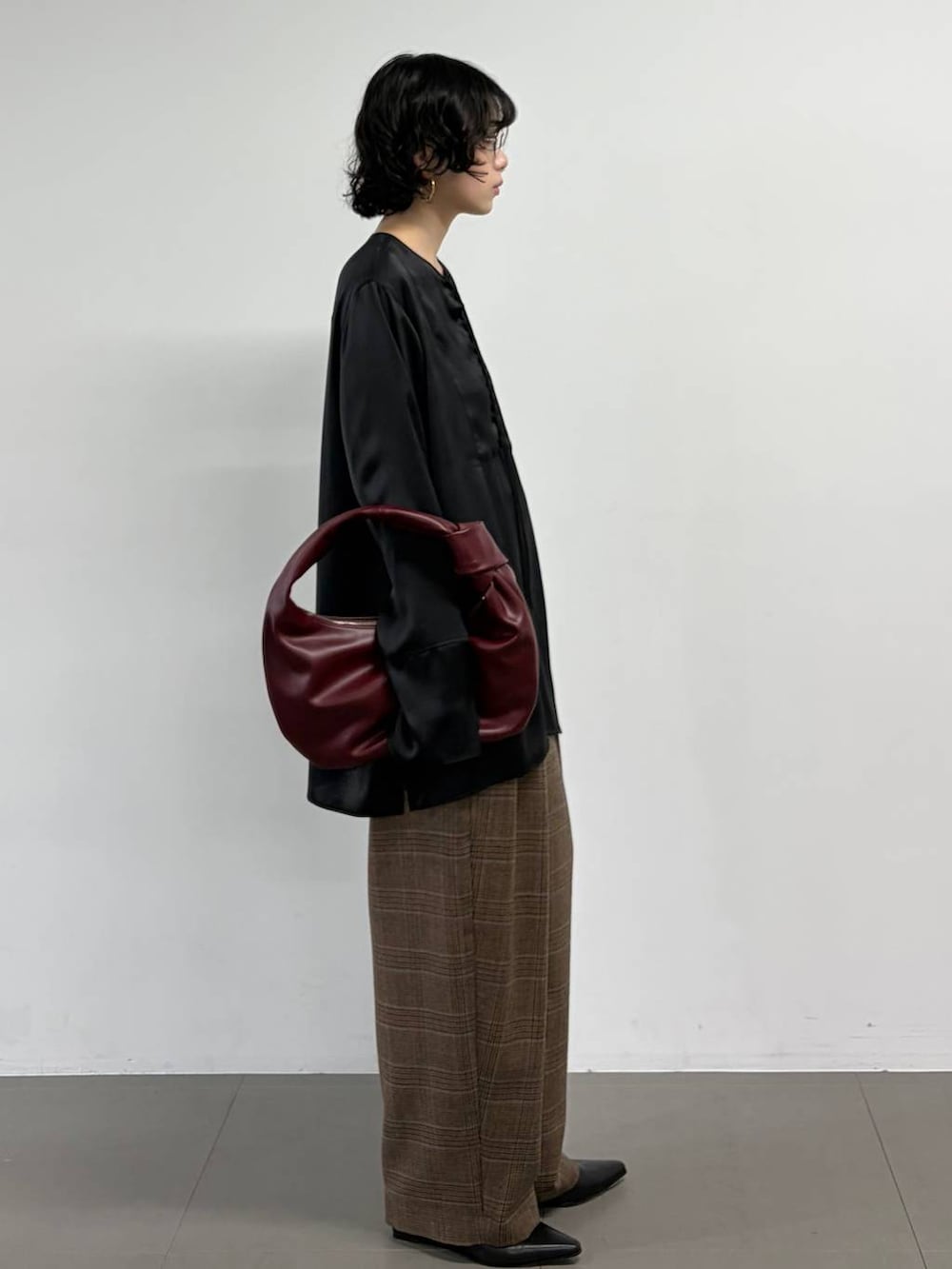 ブラック系のシャツ/ブラウス、ブラウン系のその他パンツ、ゴールド系のピアス(両耳用)を着用したレディースの秋コーディネートの2枚目の写真