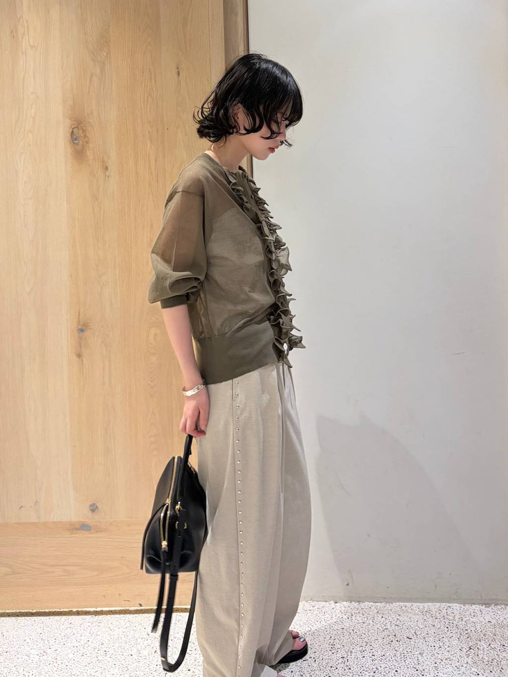 グリーン系のカーディガン/ボレロ、ベージュ系のその他パンツ、シルバー系のバングル/リストバンドを着用したレディースの夏コーディネートの2枚目の写真
