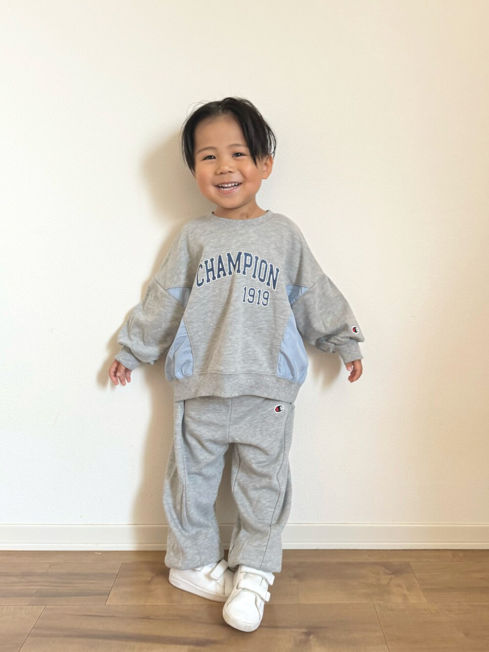 グレー系のパーカー、グレー系のスウェットパンツ、ホワイト系のスニーカーを着用したキッズの冬コーディネートの2枚目の写真