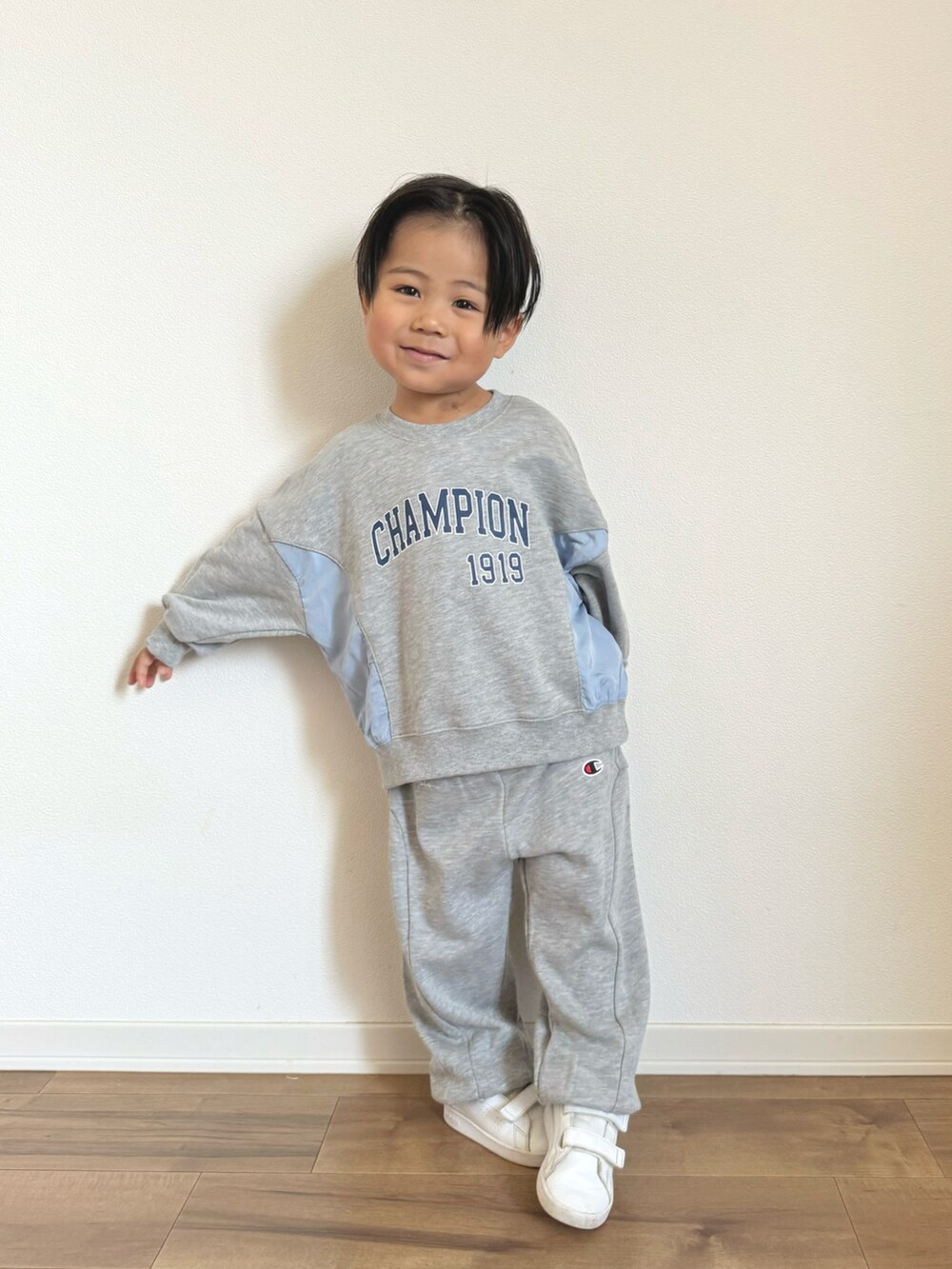 グレー系のパーカー、グレー系のスウェットパンツ、ホワイト系のスニーカーを着用したキッズの冬コーディネートの3枚目の写真