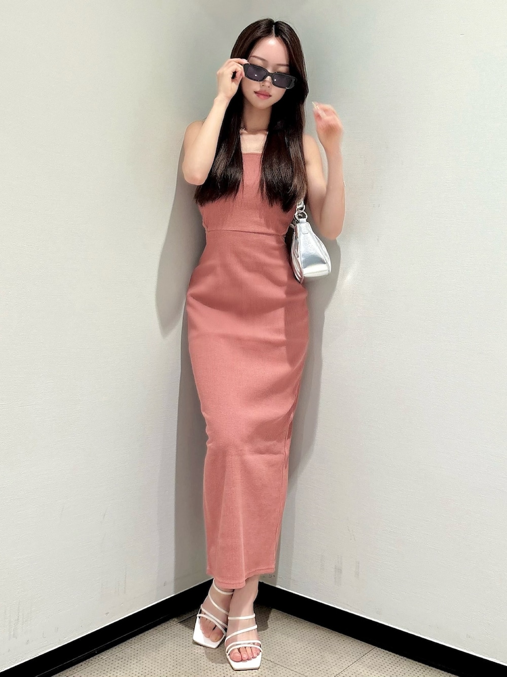 ホワイト系のサンダル、シルバー系のハンドバッグ、オレンジ系のワンピースを着用したレディースの夏コーディネートの2枚目の写真