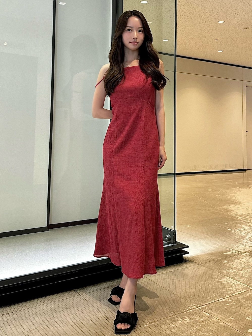 ホワイト系のワンピース、ブラック系のサンダルを着用したレディースの夏コーディネートの2枚目の写真