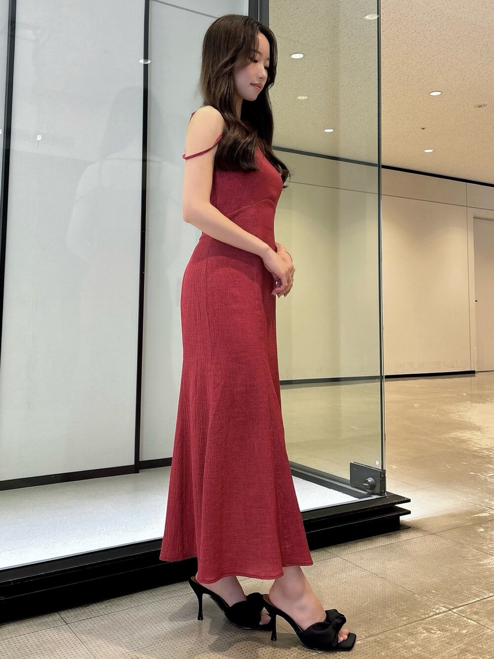 ホワイト系のワンピース、ブラック系のサンダルを着用したレディースの夏コーディネートの3枚目の写真