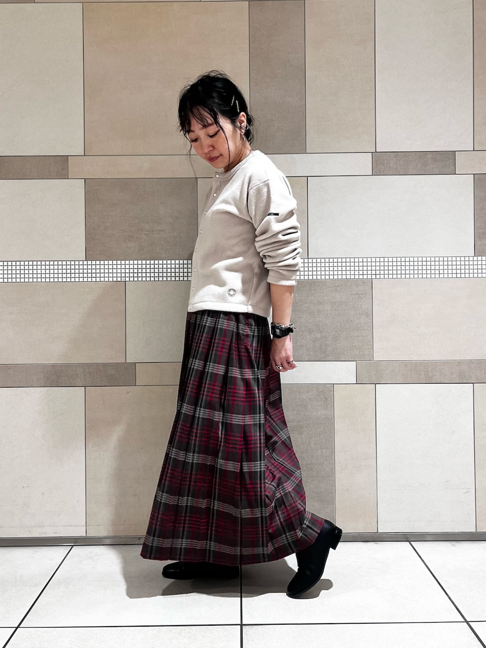 ブラック系のブーツ、ブラウン系のスカート、ベージュ系のカーディガン/ボレロを着用したレディースの秋コーディネートの5枚目の写真