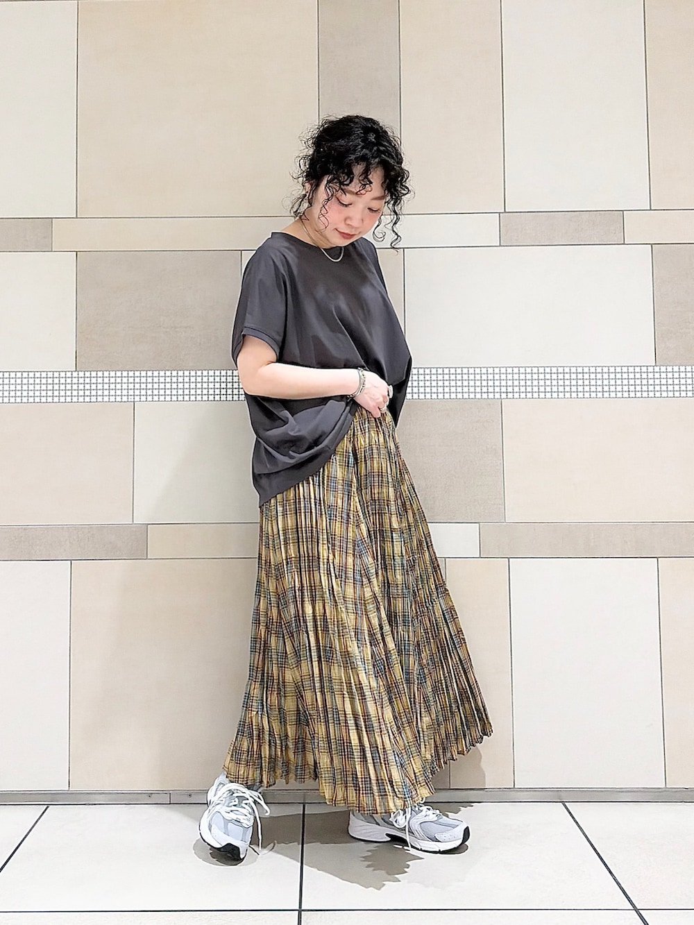 グレー系のスニーカー、イエロー系のスカート、グレー系のTシャツ/カットソーを着用したレディースの春コーディネートの3枚目の写真