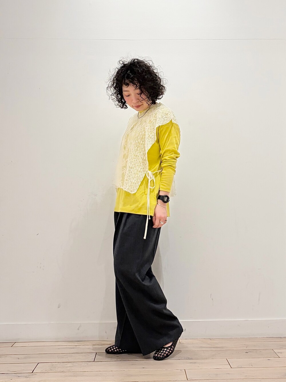 ブラック系のサンダル、イエロー系のTシャツ/カットソー、ベージュ系のストール/ショールを着用したレディースの春コーディネートの4枚目の写真