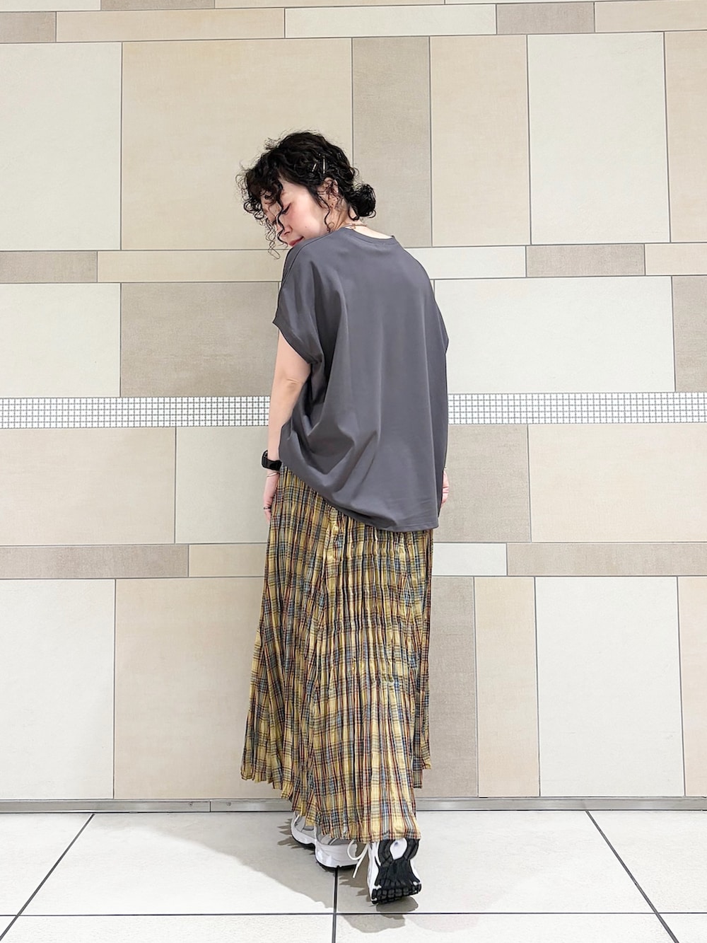 グレー系のスニーカー、イエロー系のスカート、グレー系のTシャツ/カットソーを着用したレディースの春コーディネートの6枚目の写真