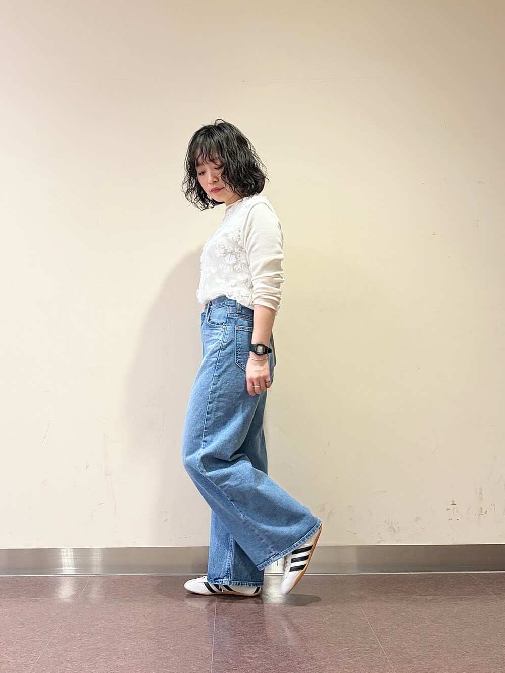 ホワイト系のスニーカー、ブルー系のデニムパンツ、ホワイト系のタンクトップを着用したレディースの春コーディネートの6枚目の写真