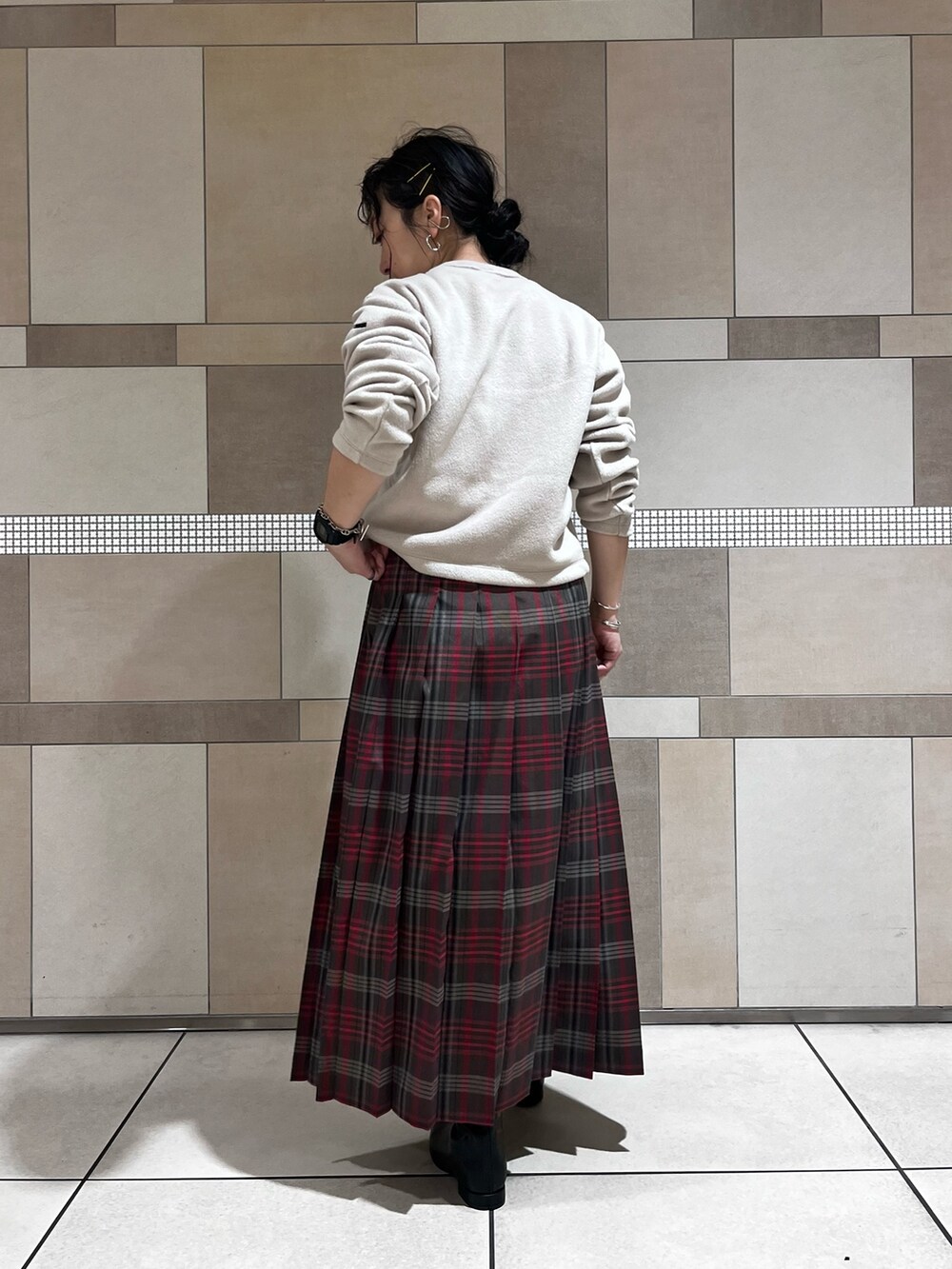 ブラック系のブーツ、ブラウン系のスカート、ベージュ系のカーディガン/ボレロを着用したレディースの秋コーディネートの7枚目の写真