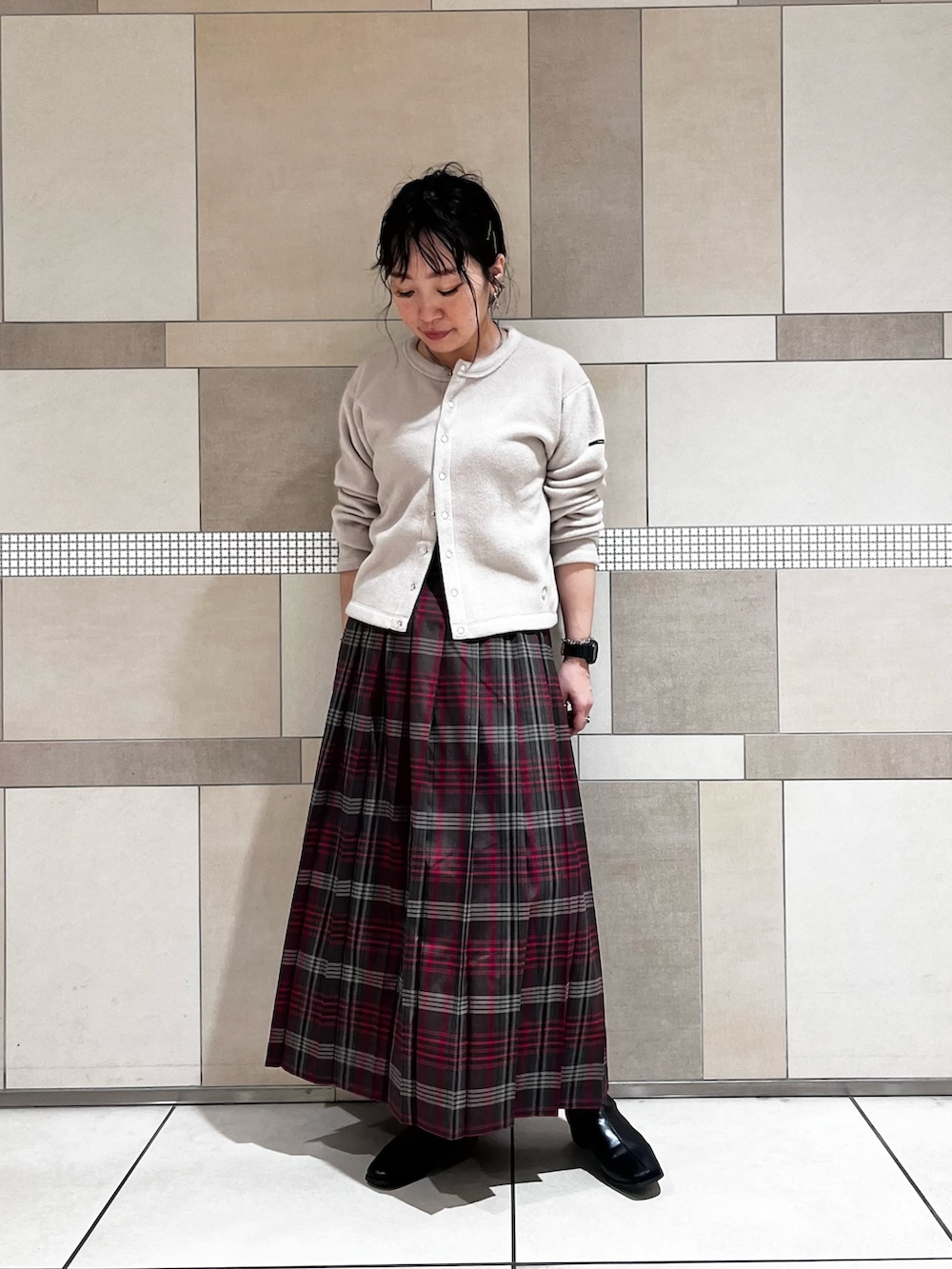 ブラック系のブーツ、ブラウン系のスカート、ベージュ系のカーディガン/ボレロを着用したレディースの秋コーディネートの3枚目の写真