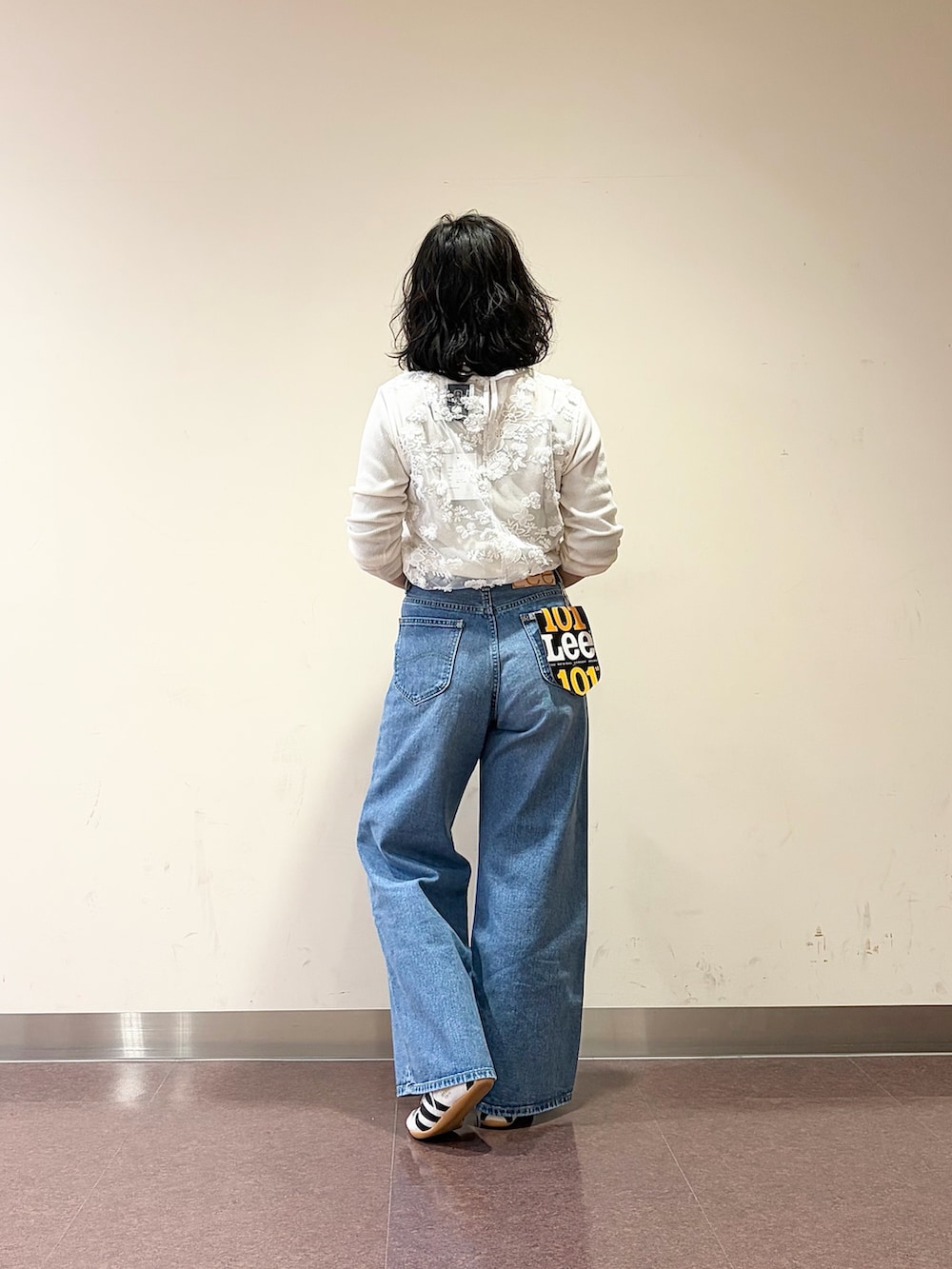 ホワイト系のスニーカー、ブルー系のデニムパンツ、ホワイト系のタンクトップを着用したレディースの春コーディネートの8枚目の写真