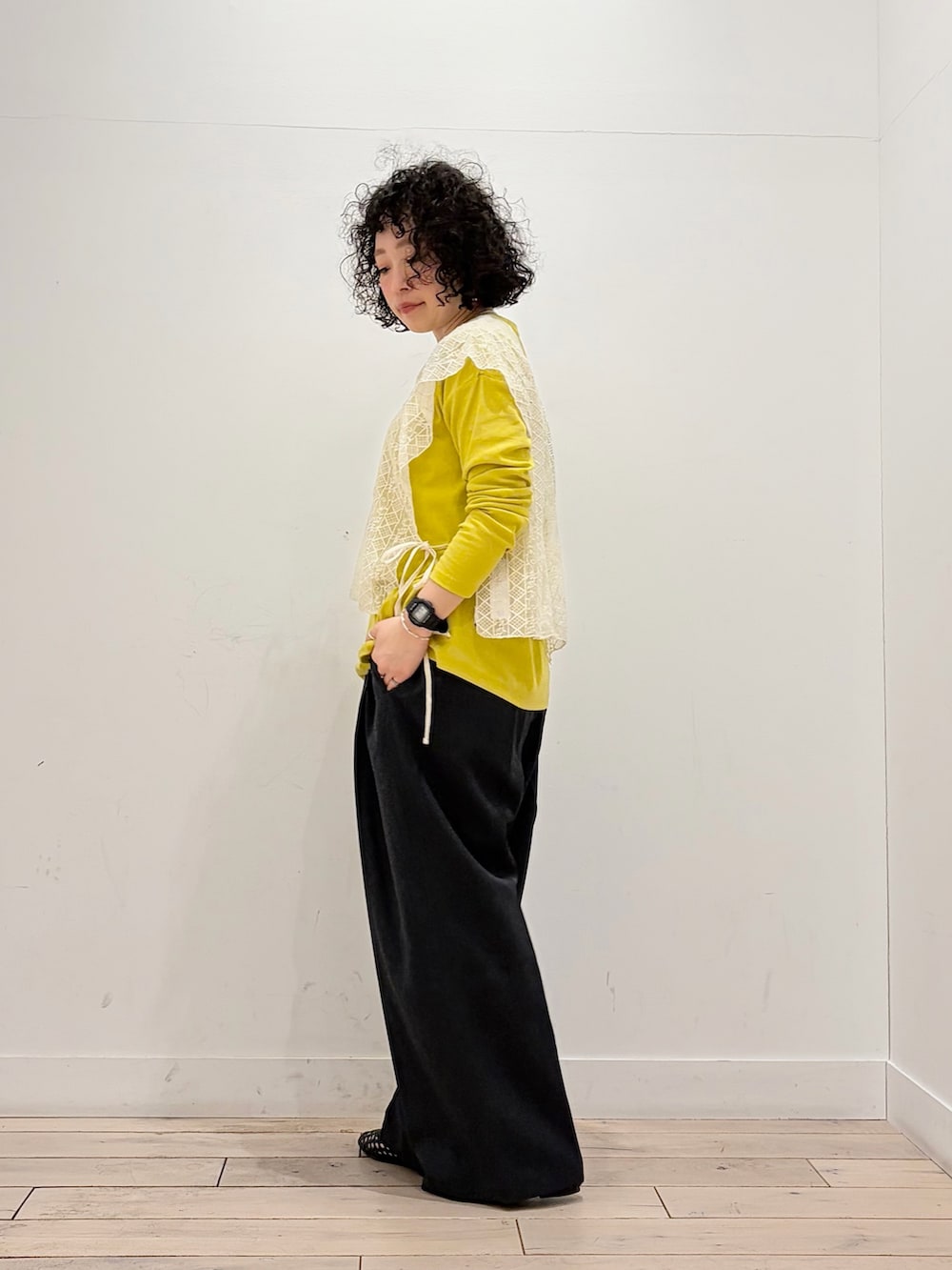 ブラック系のサンダル、イエロー系のTシャツ/カットソー、ベージュ系のストール/ショールを着用したレディースの春コーディネートの3枚目の写真