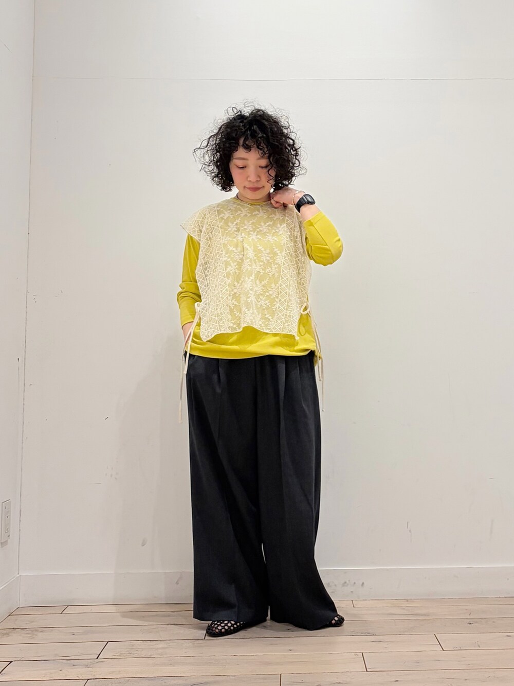 ブラック系のサンダル、イエロー系のTシャツ/カットソー、ベージュ系のストール/ショールを着用したレディースの春コーディネートの2枚目の写真