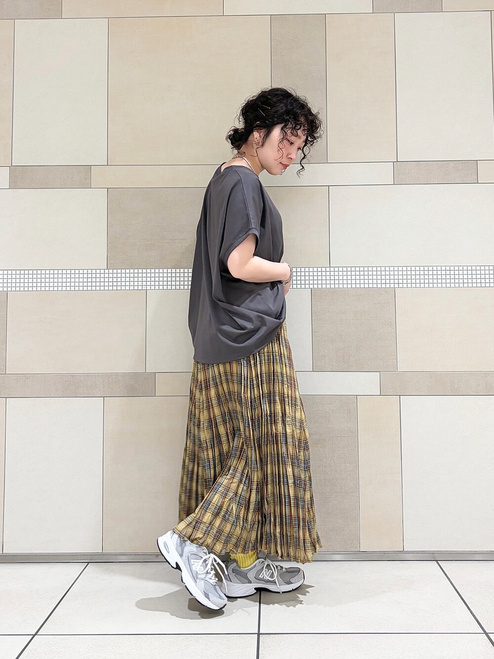 グレー系のスニーカー、イエロー系のスカート、グレー系のTシャツ/カットソーを着用したレディースの春コーディネートの4枚目の写真