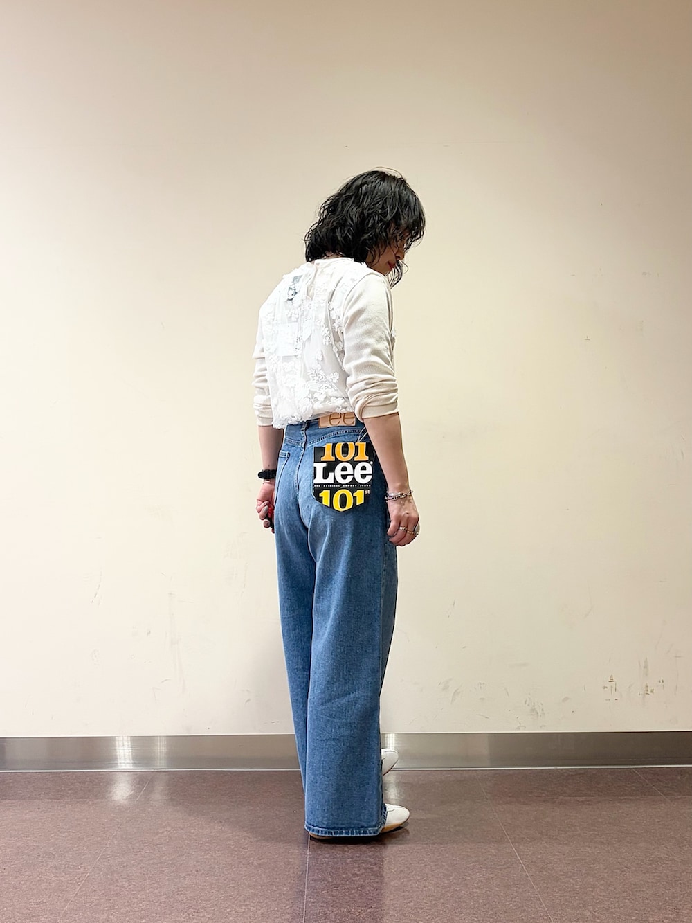 ホワイト系のスニーカー、ブルー系のデニムパンツ、ホワイト系のタンクトップを着用したレディースの春コーディネートの7枚目の写真