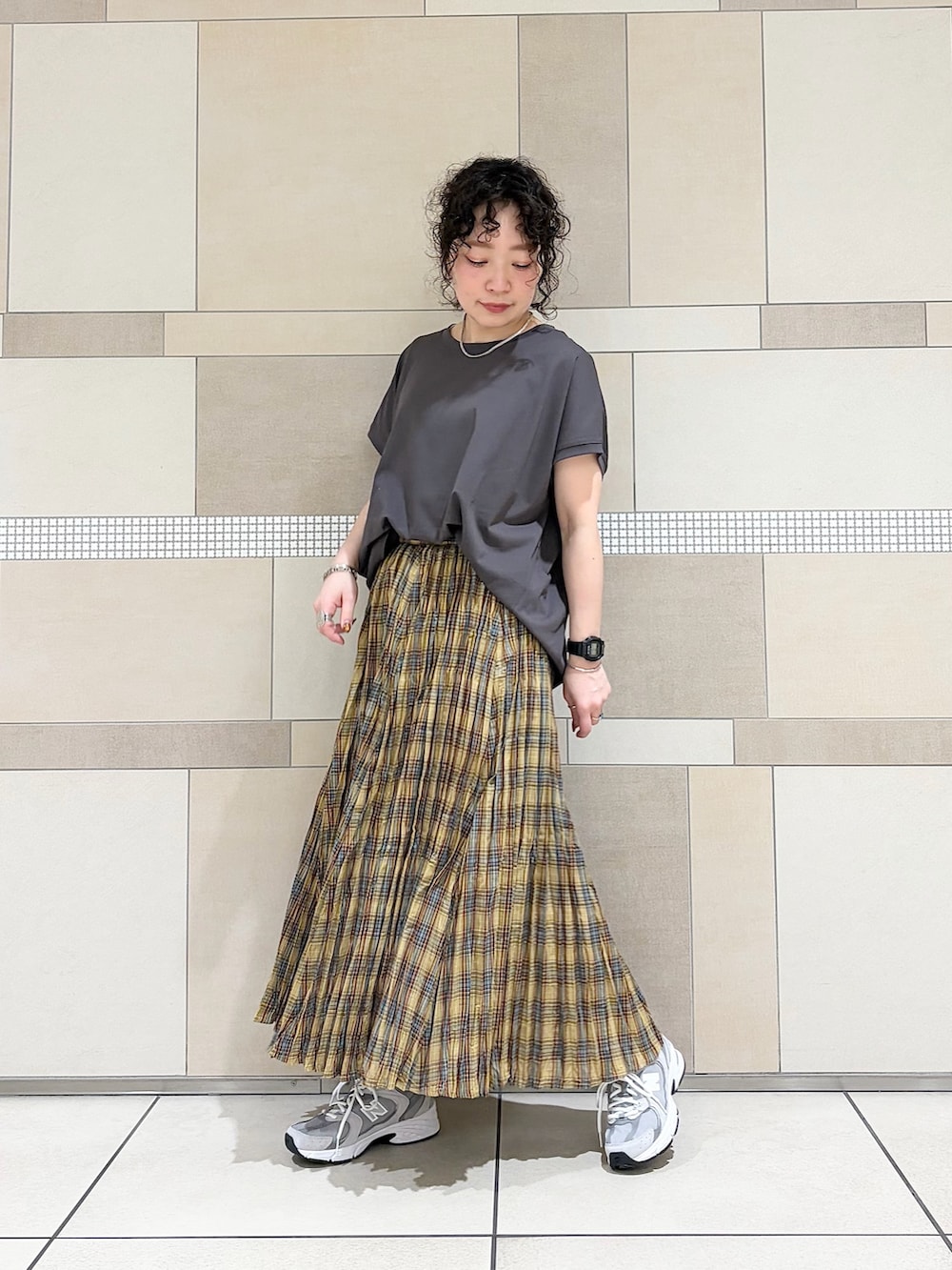 グレー系のスニーカー、イエロー系のスカート、グレー系のTシャツ/カットソーを着用したレディースの春コーディネートの2枚目の写真