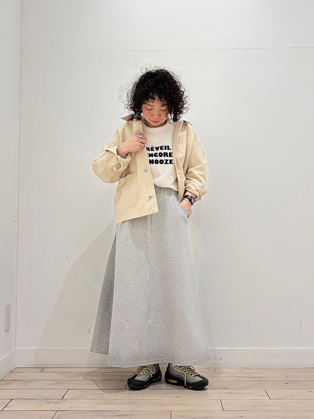 グレー系のスカート、その他のTシャツ/カットソー、ホワイト系のカバーオールを着用したレディースの春コーディネートの2枚目の写真