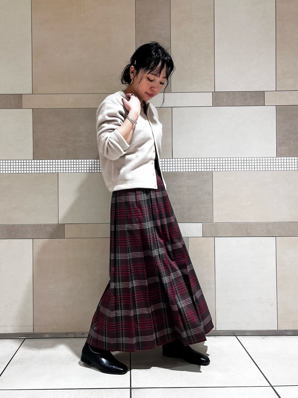 ブラック系のブーツ、ブラウン系のスカート、ベージュ系のカーディガン/ボレロを着用したレディースの秋コーディネートの6枚目の写真