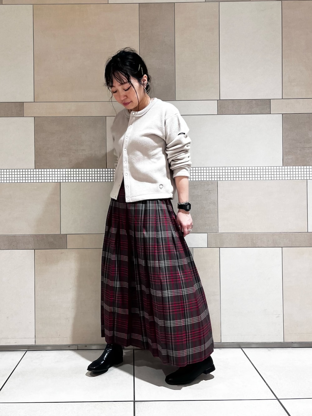 ブラック系のブーツ、ブラウン系のスカート、ベージュ系のカーディガン/ボレロを着用したレディースの秋コーディネートの4枚目の写真