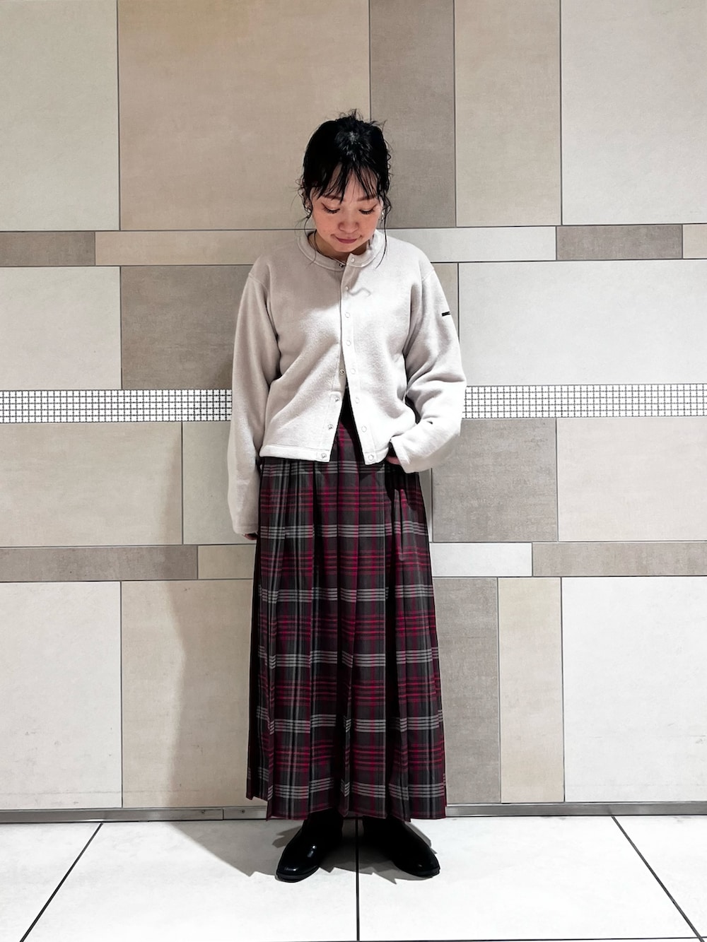 ブラック系のブーツ、ブラウン系のスカート、ベージュ系のカーディガン/ボレロを着用したレディースの秋コーディネートの2枚目の写真