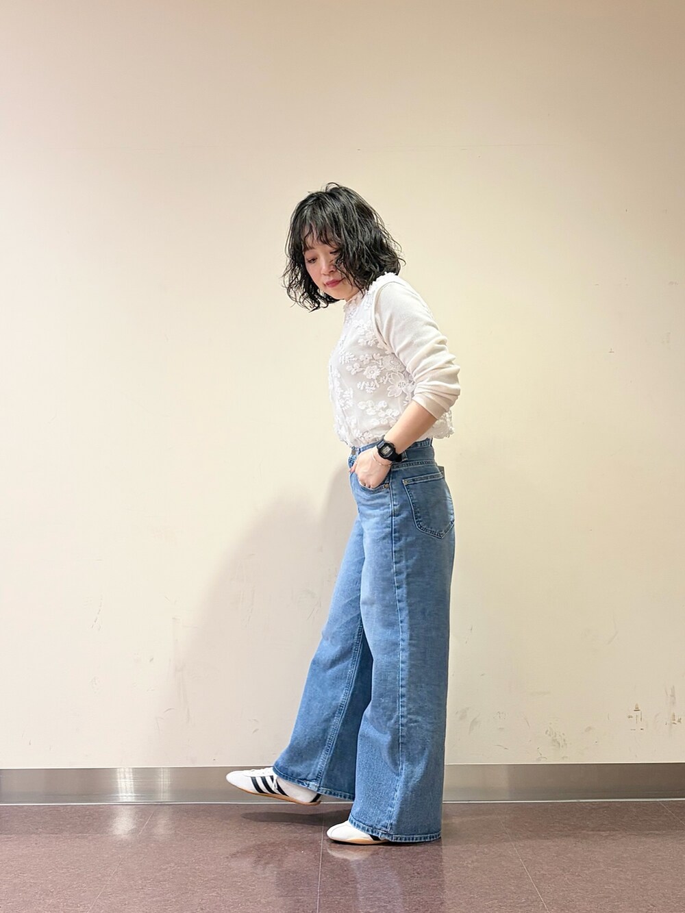 ホワイト系のスニーカー、ブルー系のデニムパンツ、ホワイト系のタンクトップを着用したレディースの春コーディネートの5枚目の写真