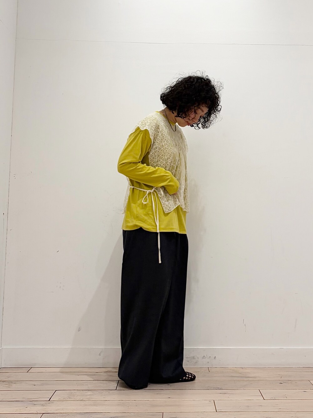 ブラック系のサンダル、イエロー系のTシャツ/カットソー、ベージュ系のストール/ショールを着用したレディースの春コーディネートの5枚目の写真