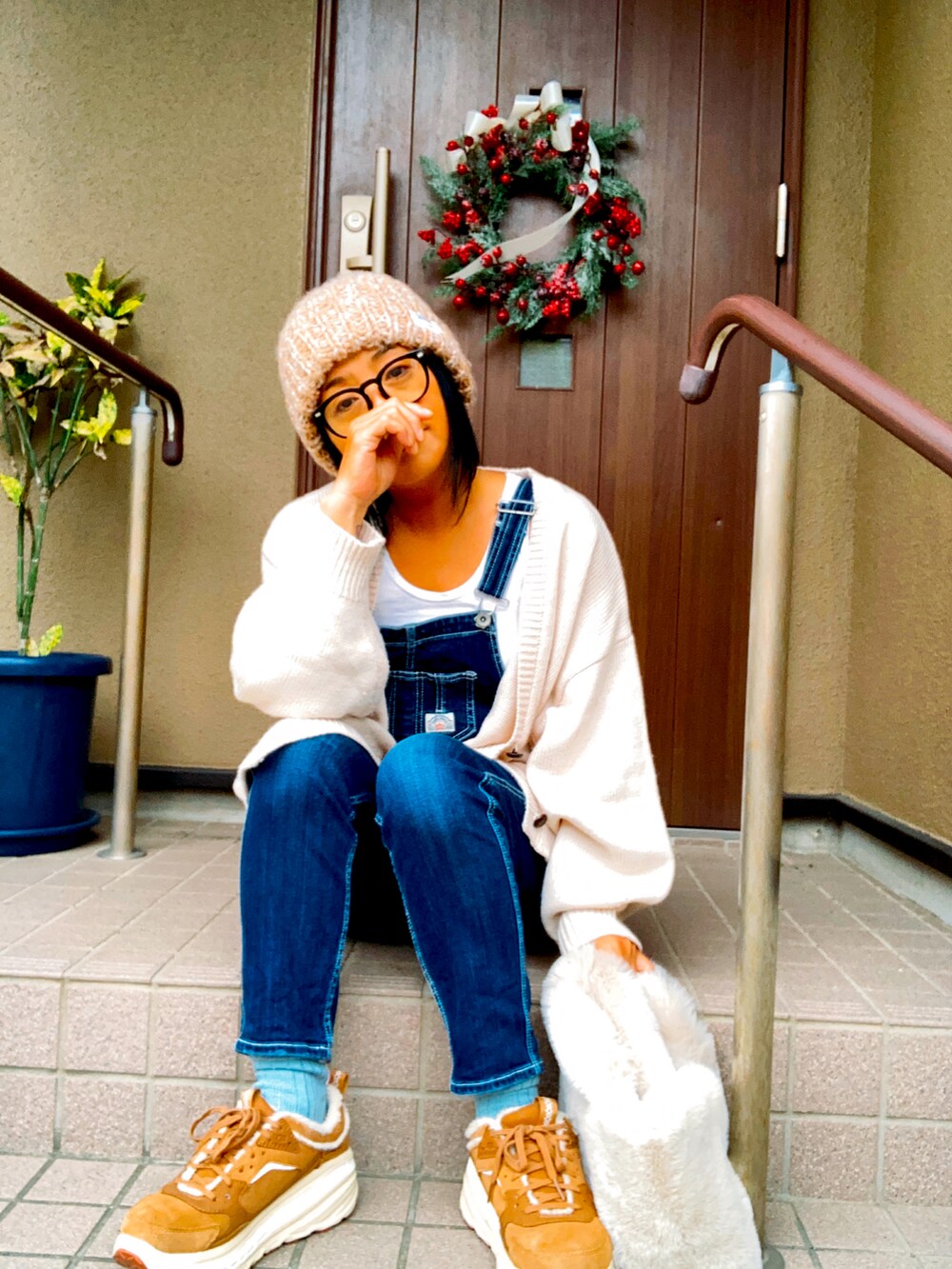 ブルー系のサロペット/オーバーオール、ベージュ系のスニーカー、ベージュ系のハンドバッグを着用したレディースの秋コーディネートの3枚目の写真