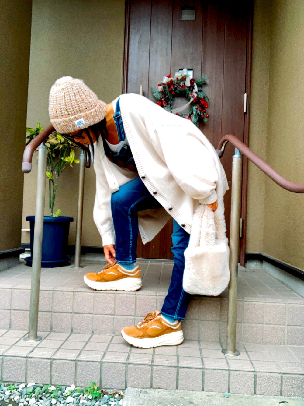 ブルー系のサロペット/オーバーオール、ベージュ系のスニーカー、ベージュ系のハンドバッグを着用したレディースの秋コーディネートの2枚目の写真