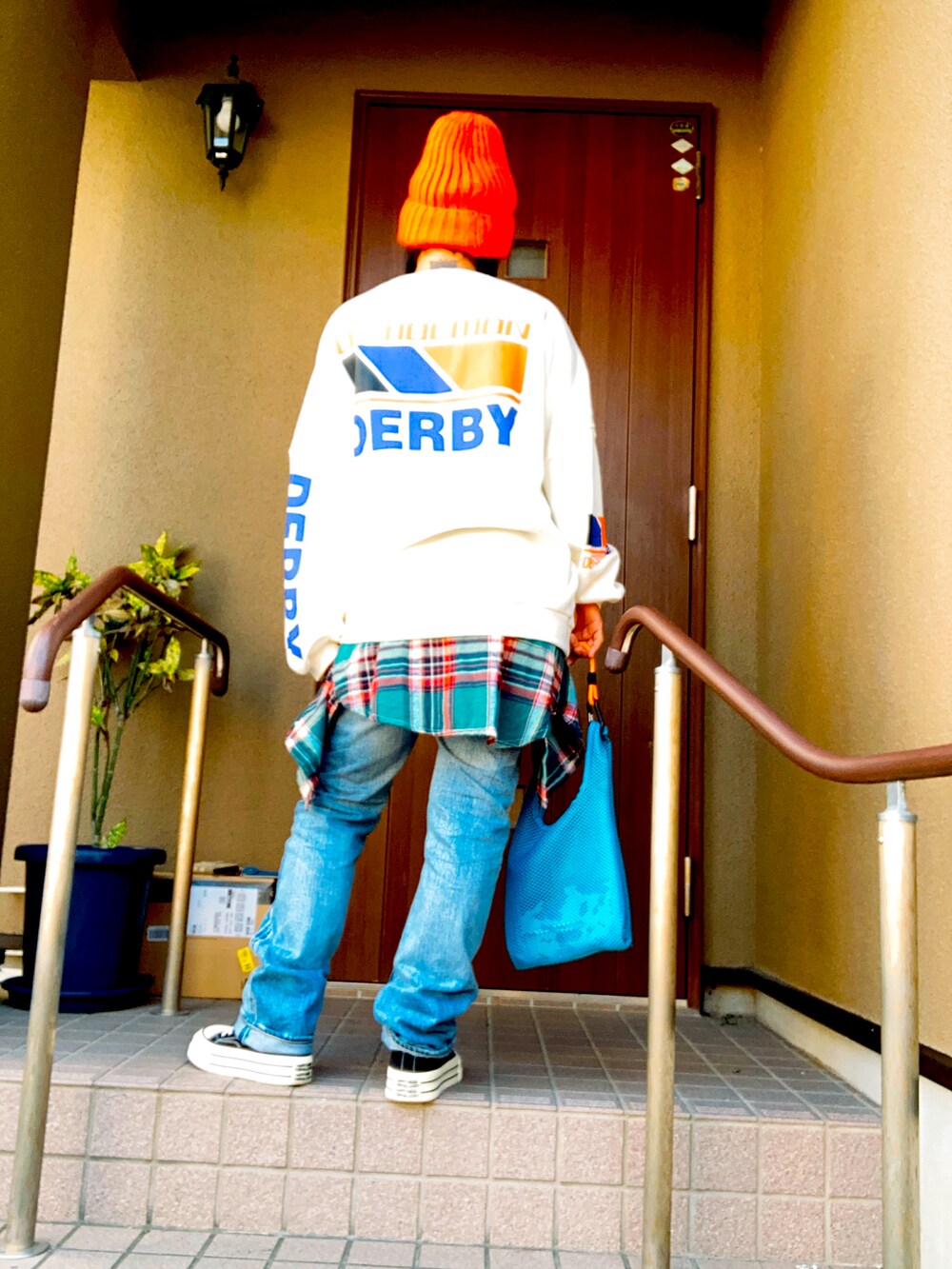 ホワイト系のスウェット、ブルー系のデニムパンツ、ブルー系のトートバッグを着用したレディースの秋コーディネートの3枚目の写真