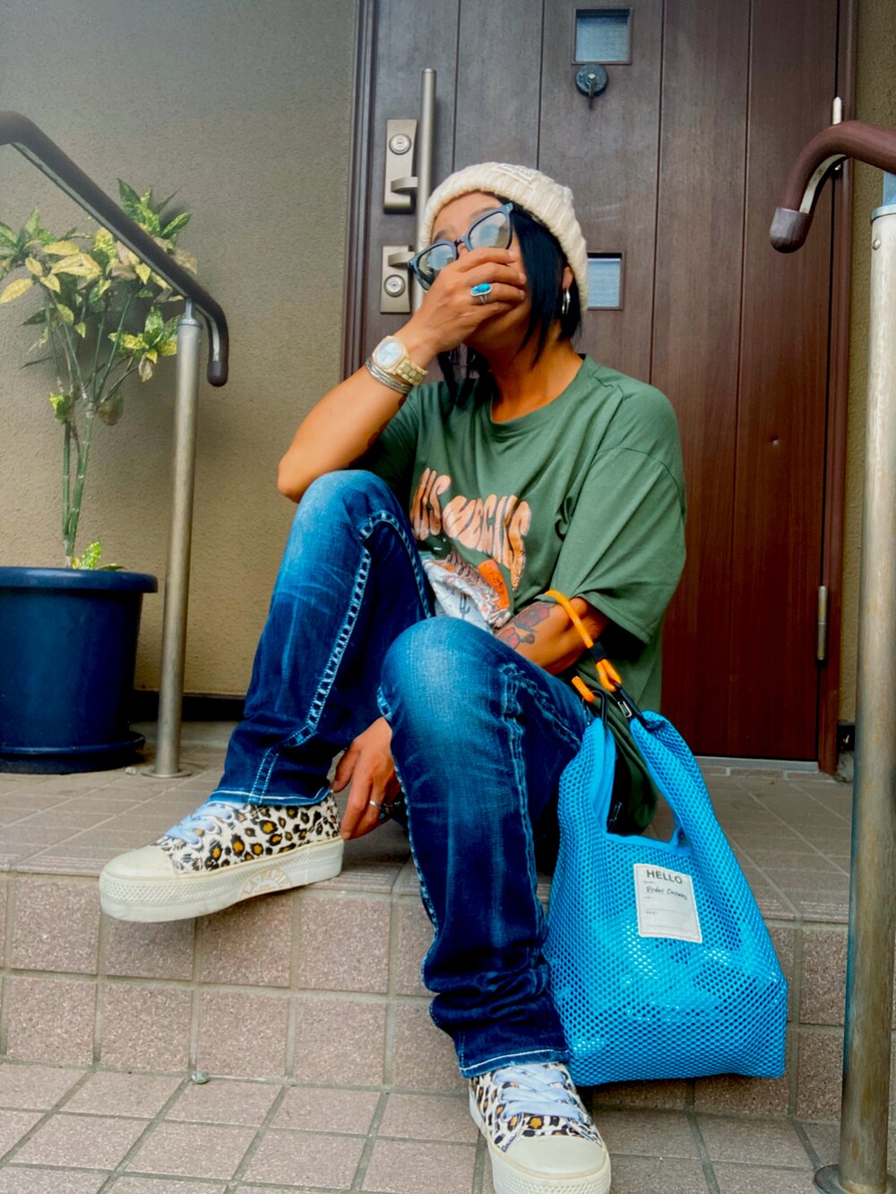 ブラウン系のスニーカー、ブルー系のデニムパンツ、グリーン系のTシャツ/カットソーを着用したレディースの夏コーディネートの2枚目の写真