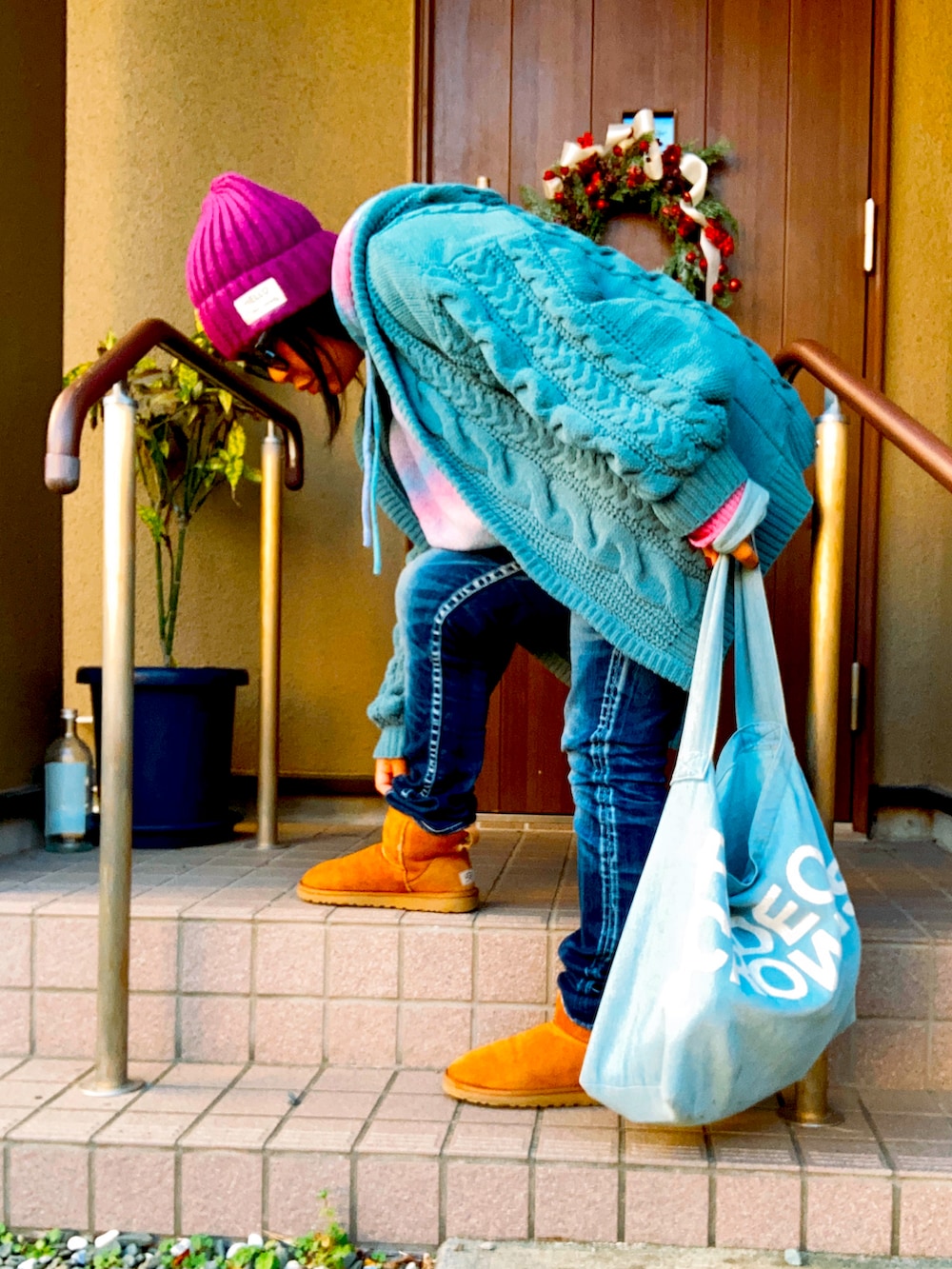 グリーン系のニット/セーター、ピンク系のニット/セーター、ブルー系のデニムパンツを着用したレディースの冬コーディネートの2枚目の写真