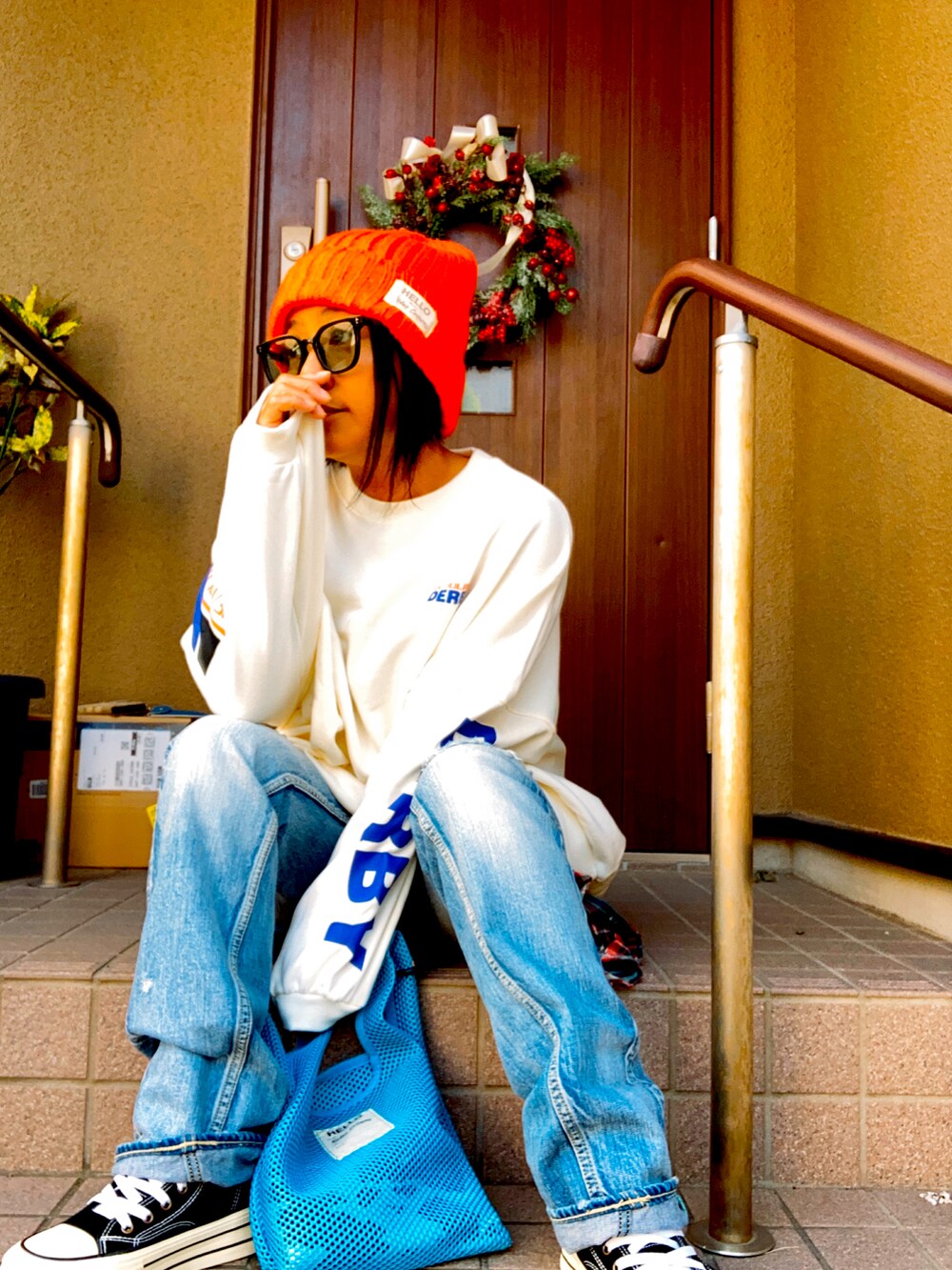 ホワイト系のスウェット、ブルー系のデニムパンツ、ブルー系のトートバッグを着用したレディースの秋コーディネートの2枚目の写真