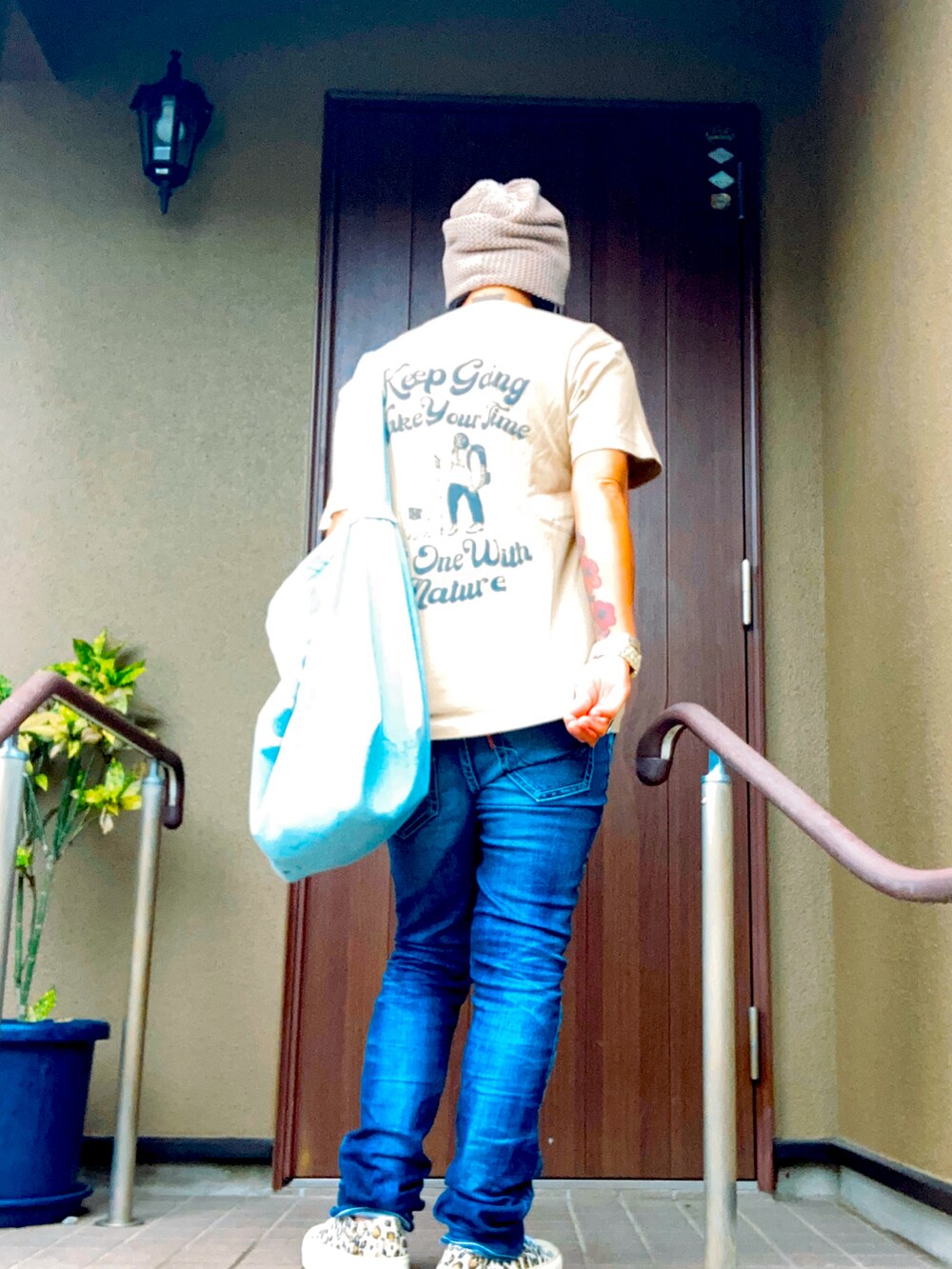 ベージュ系のTシャツ/カットソー、ブルー系のデニムパンツ、ベージュ系のスニーカーを着用したレディースの夏コーディネートの3枚目の写真