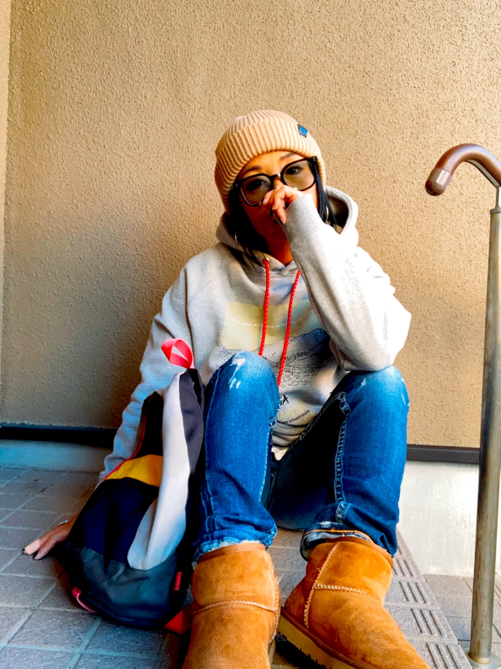 グレー系のパーカー、グレー系のボディバッグ/ウエストポーチ、ベージュ系のブーツを着用したレディースの冬コーディネートの2枚目の写真