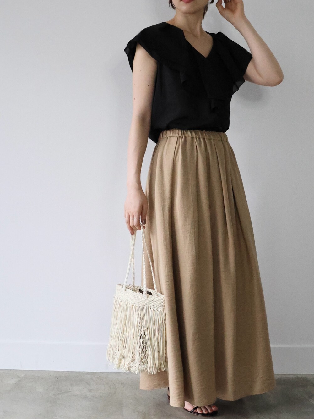 ブラック系のシャツ/ブラウス、ベージュ系のスカート、ブラック系のサンダルを着用したレディースの夏コーディネートの4枚目の写真