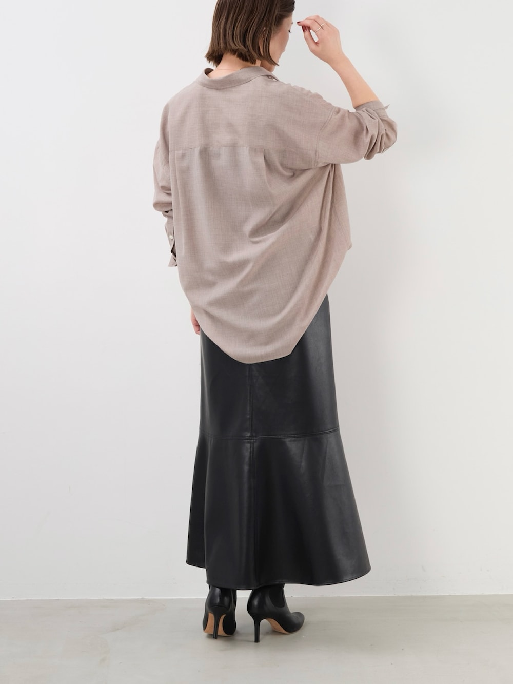 ブラック系のスカート、ベージュ系のシャツ/ブラウスを着用したレディースの秋コーディネートの6枚目の写真