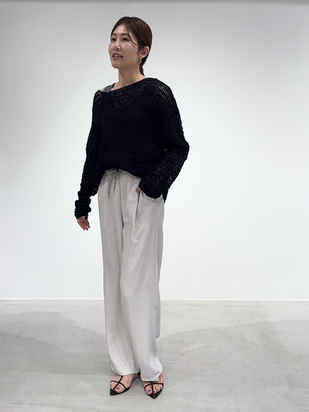 ホワイト系のその他パンツ、ブラック系のニット/セーター、グレー系のタンクトップを着用したレディースの春コーディネートの3枚目の写真