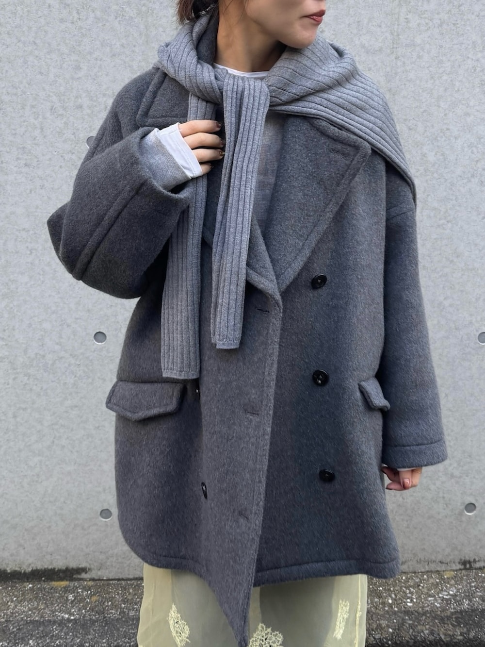 グレー系のピーコート、グレー系のニット/セーターを着用したレディースの冬コーディネートの4枚目の写真