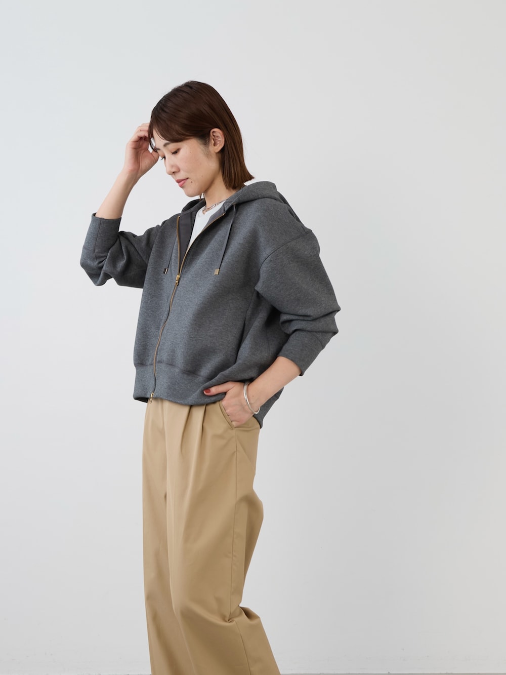 グレー系のパーカーを着用したレディースの冬コーディネートの3枚目の写真