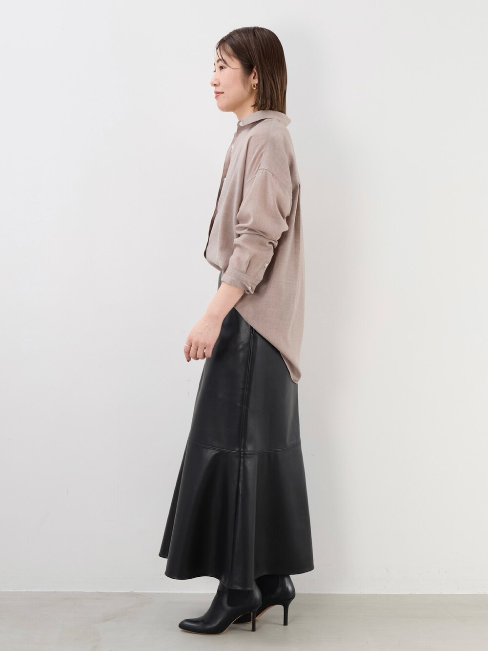 ブラック系のスカート、ベージュ系のシャツ/ブラウスを着用したレディースの秋コーディネートの5枚目の写真