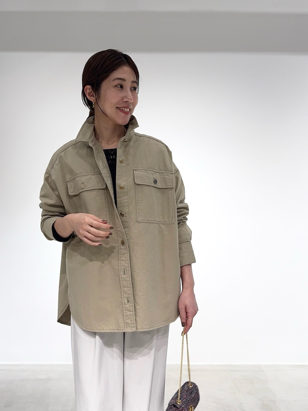 ベージュ系のシャツ/ブラウス、ブラック系のニット/セーター、その他のショルダーバッグを着用したレディースの春コーディネートの4枚目の写真