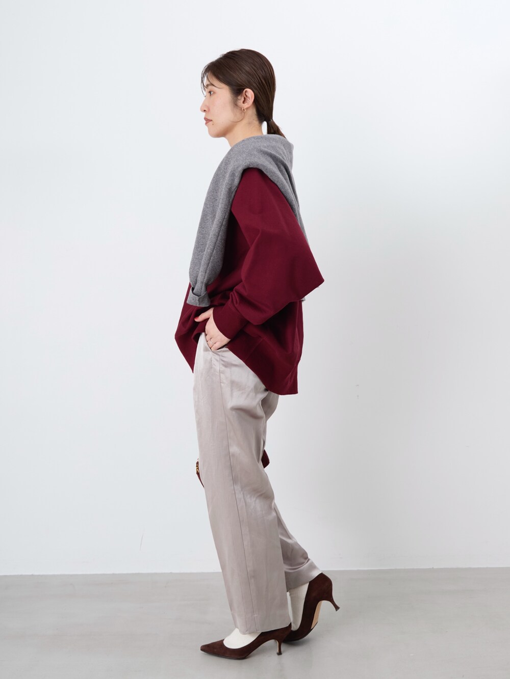 レッド系のスウェット、グレー系のニット/セーター、ベージュ系のその他パンツを着用したレディースの冬コーディネートの2枚目の写真