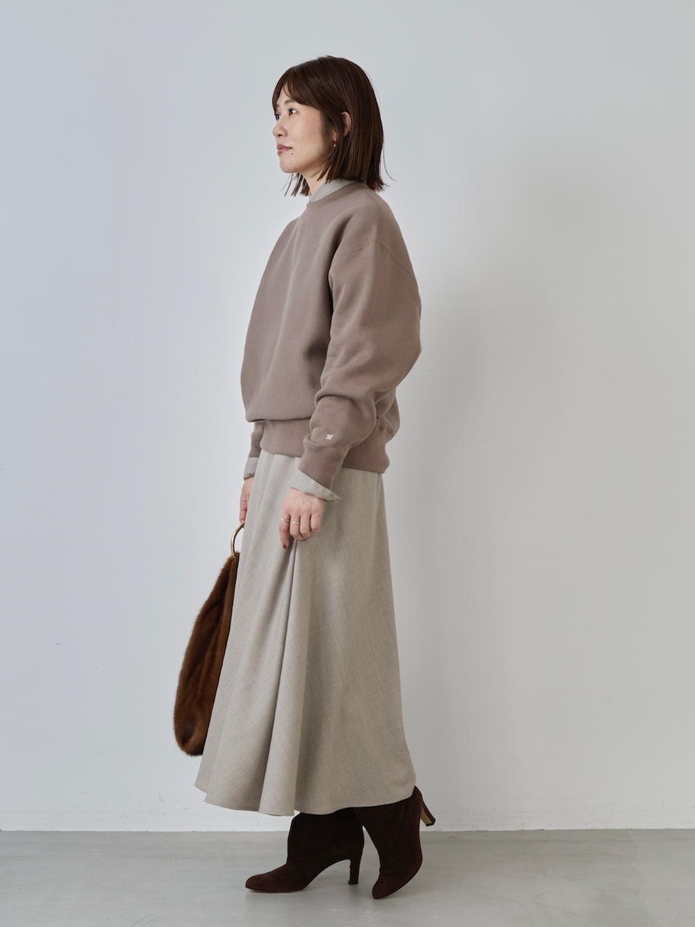 ベージュ系のスカート、ベージュ系のシャツ/ブラウス、ブラウン系のスウェットを着用したレディースの冬コーディネートの4枚目の写真