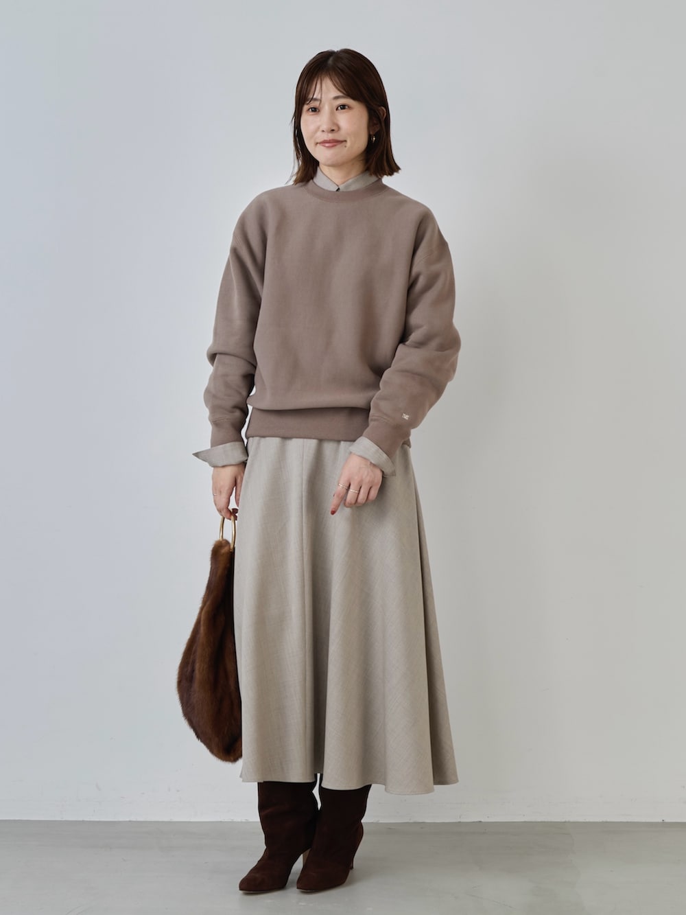ベージュ系のスカート、ベージュ系のシャツ/ブラウス、ブラウン系のスウェットを着用したレディースの冬コーディネートの2枚目の写真