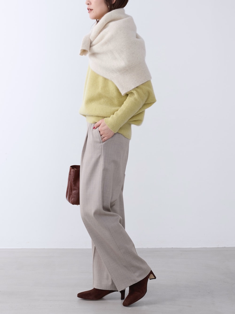 イエロー系のニット/セーター、ホワイト系のニット/セーター、ベージュ系のその他パンツを着用したレディースの冬コーディネートの5枚目の写真